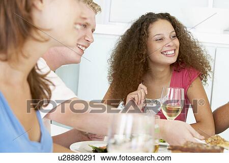 Stock Image - Friends Having Lunch Together At Home. Fotosearch