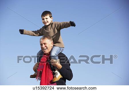 Picture - Grandfather Carrying Grandson On His Shoulders. Fotosearch