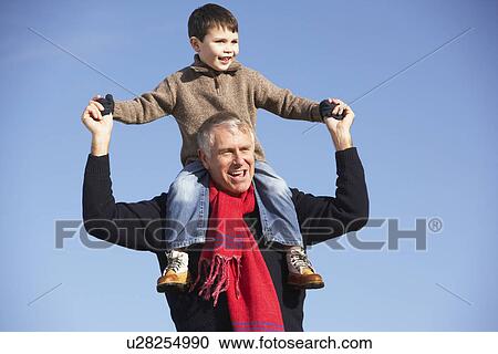 Stock Image - Grandfather Carrying Grandson On His Shoulders. Fotosearch