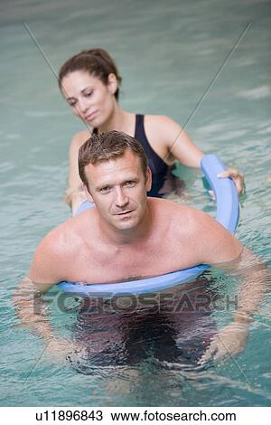Stock Image - Instructor And Patient Undergoing Water Therapy. Fotosearch