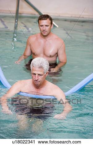 Stock Image - Instructor And Patient Undergoing Water Therapy. Fotosearch