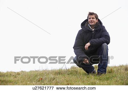 Stock Photo - Man Crouching In Park. Fotosearch
