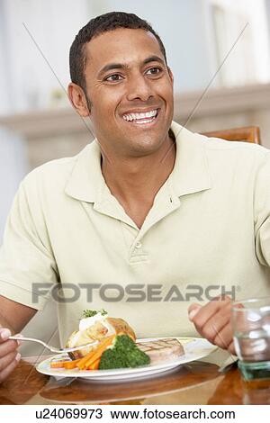 Stock Image - Man Enjoying A Meal At Home. Fotosearch