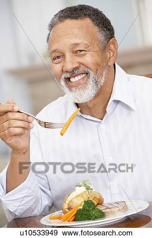 Stock Photo - Man Enjoying A Meal At Home. Fotosearch