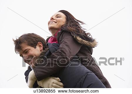 Stock Photography - Man Giving His Wife Piggy Back Ride. Fotosearch