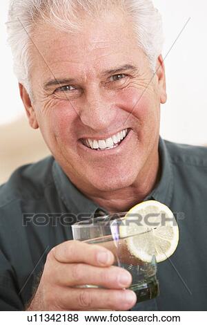 Stock Photo - Man Having A Drink At Home. Fotosearch
