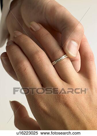 Man Putting Diamond Ring On Woman's Finger View Large Photo Image Stock Photography - Man Putting Diamond Ring On Woman's Finger. Fotosearch