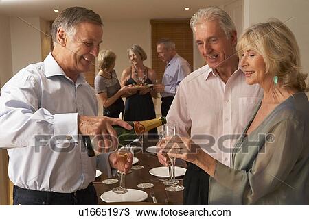 Man Serving Champagne To His Guests At A Dinner Party View Large Photo Image Stock Image - Man Serving Champagne To His Guests At A Dinner Party. Fotosearch