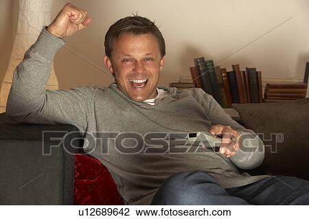 Stock Image - Man Watching Television Excitedly. Fotosearch