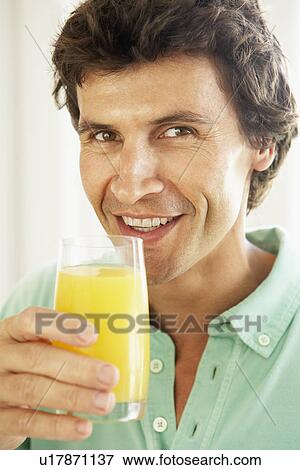 Mid Adult Man Drinking A Glass Of Orange Juice View Large Photo Image Stock Photo - Mid Adult Man Drinking A Glass Of Orange Juice. Fotosearch