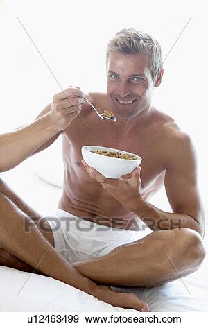 Stock Photo - Mid Adult Man Eating A Bowl Of Cereal. Fotosearch