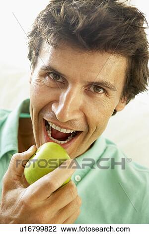 Stock Image - Mid Adult Man Eating A Healthy Apple. Fotosearch