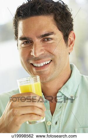 Mid Adult Man Holding A Glass Of Fresh Orange Juice, Smiling At The Camera View Large Photo Image Stock Image - Mid Adult Man Holding A Glass Of Fresh Orange Juice, Smiling At The Camera. Fotosearch