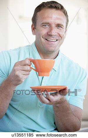 Mid Adult Man Holding Orange Mug And Smiling At The Camera View Large Photo Image Stock Photography - Mid Adult Man Holding Orange Mug And Smiling At The Camera. Fotosearch