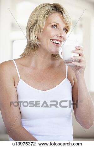 Stock Image - Mid Adult Woman Drinking A Glass Of Milk. Fotosearch