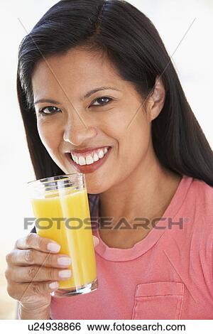 Stock Photograph - Mid Adult Woman Drinking Fresh Orange Juice. Fotosearch