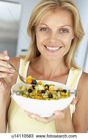 Mid Adult Woman Eating A Bowl Of Fresh Fruit View Large Photo Image Stock Image - Mid Adult Woman Eating A Bowl Of Fresh Fruit. Fotosearch