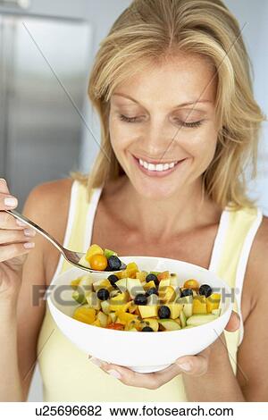 Mid Adult Woman Eating A Bowl Of Fresh Fruit View Large Photo Image Stock Image - Mid Adult Woman Eating A Bowl Of Fresh Fruit. Fotosearch