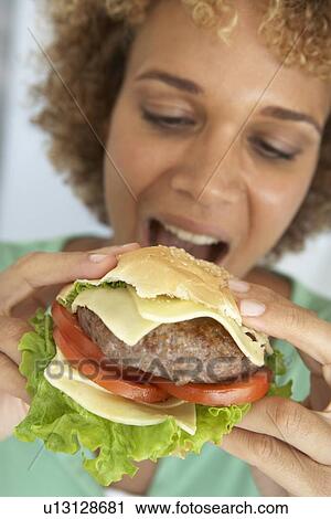 Mid Adult Woman Eating A Burger View Large Photo Image Stock Image - Mid Adult Woman Eating A Burger. Fotosearch