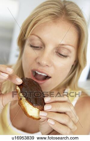 Mid Adult Woman Eating A Chocolate Eclair View Large Photo Image Stock Photo - Mid Adult Woman Eating A Chocolate Eclair. Fotosearch