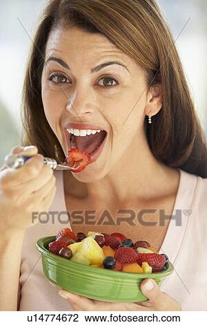 Mid Adult Woman Eating A Fresh Fruit Salad View Large Photo Image Stock Image - Mid Adult Woman Eating A Fresh Fruit Salad. Fotosearch