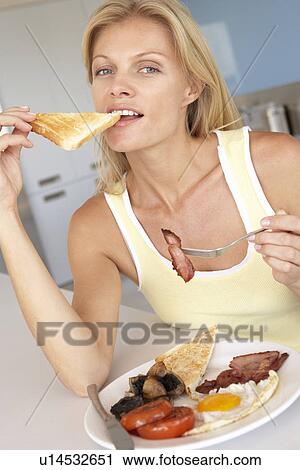 Mid Adult Woman Eating Unhealthy Fried Breakfast View Large Photo Image Stock Image - Mid Adult Woman Eating Unhealthy Fried Breakfast. Fotosearch