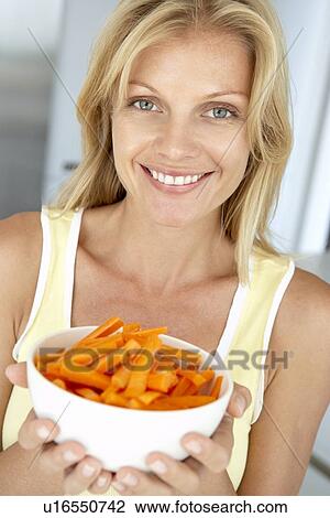 Mid Adult Woman Holding A Bowl Of Carrots View Large Photo Image Stock Image - Mid Adult Woman Holding A Bowl Of Carrots. Fotosearch