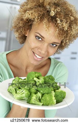 Mid Adult Woman Holding A Plate Of Broccoli, Smiling At The Camera View Large Photo Image Stock Photo - Mid Adult Woman Holding A Plate Of Broccoli, Smiling At The Camera. Fotosearch
