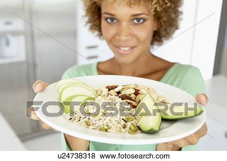 Stock Photo - Mid Adult Woman Holding A Plate With Healthy Food. Fotosearch