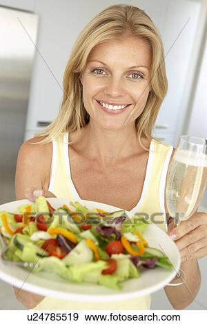 Mid Adult Woman Holding A Wine Glass And Fresh Salad View Large Photo Image Stock Photo - Mid Adult Woman Holding A Wine Glass And Fresh Salad. Fotosearch