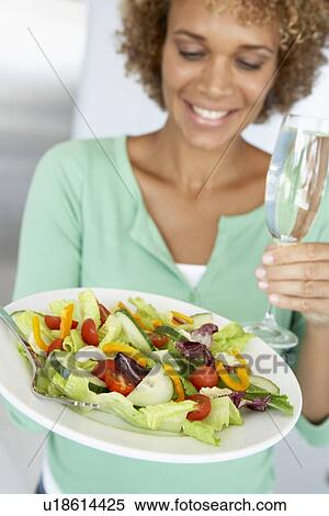 Stock Photography - Mid Adult Woman Holding A Wine Glass And Fresh Salad. Fotosearch