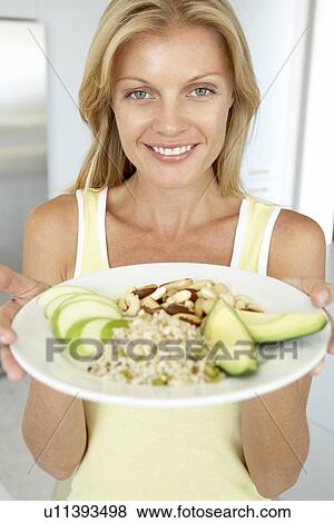 Stock Photo - Mid Adult Woman Holding Plate With Healthy Foods. Fotosearch
