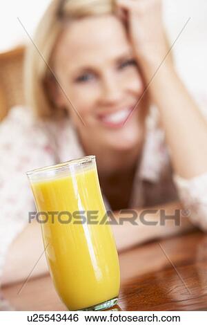 Mid Adult Woman Looking At A Glass Of Fresh Orange Juice View Large Photo Image Stock Photograph - Mid Adult Woman Looking At A Glass Of Fresh Orange Juice. Fotosearch