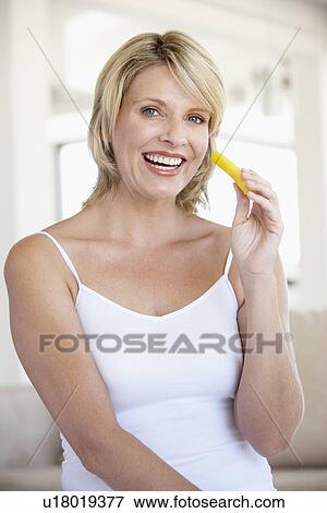 Stock Photo - Mid Adult Woman Smiling At Camera And Eating Pineapple. Fotosearch