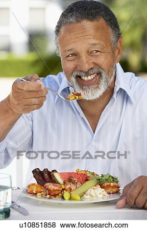 Stock Photo - Middle Aged Man Dining Al Fresco. Fotosearch