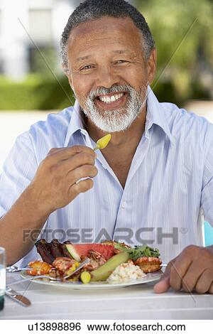 Stock Photograph - Middle Aged Man Dining Al Fresco. Fotosearch