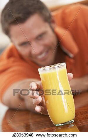 Stock Photo - Middle Aged Man Drinking Fresh Orange Juice. Fotosearch