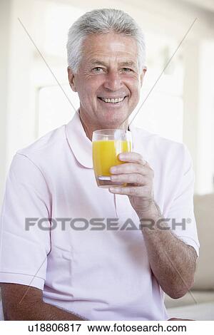 Stock Photo - Middle Aged Man Drinking Orange Juice. Fotosearch