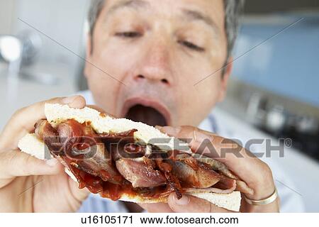 Middle Aged Man Eating A Bacon Sandwich View Large Photo Image Stock Image - Middle Aged Man Eating A Bacon Sandwich. Fotosearch