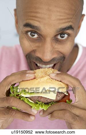 Middle Aged Man Eating A Burger View Large Photo Image Stock Image - Middle Aged Man Eating A Burger. Fotosearch