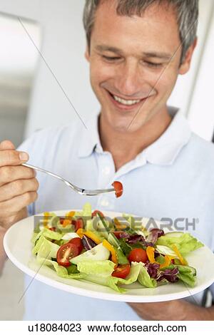 Stock Image - Middle Aged Man Eating A Healthy Salad. Fotosearch