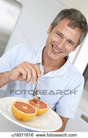 Middle Aged Man Eating Fresh Grapefruit View Large Photo Image Stock Photograph - Middle Aged Man Eating Fresh Grapefruit. Fotosearch