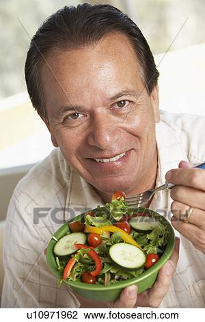Stock Image - Middle Aged Man Eating Salad. Fotosearch