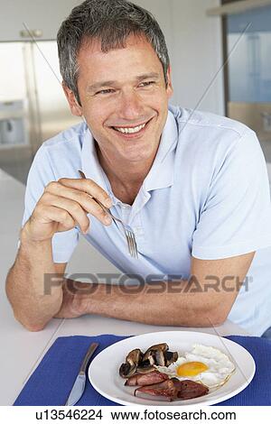 Middle Aged Man Eating Unhealthy Fried Breakfast View Large Photo Image Picture - Middle Aged Man Eating Unhealthy Fried Breakfast. Fotosearch