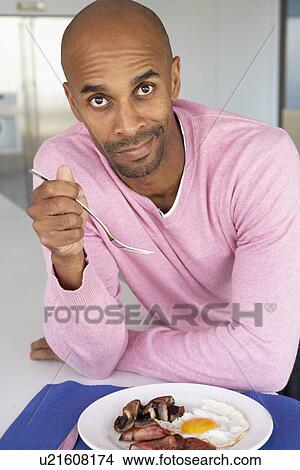 Picture - Middle Aged Man Eating Unhealthy Fried Breakfast. Fotosearch