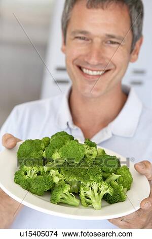 Middle Aged Man Holding A Plate Of Broccoli View Large Photo Image Picture - Middle Aged Man Holding A Plate Of Broccoli. Fotosearch