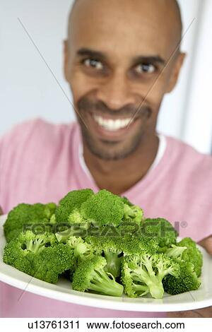 Stock Image - Middle Aged Man Holding A Plate Of Broccoli. Fotosearch