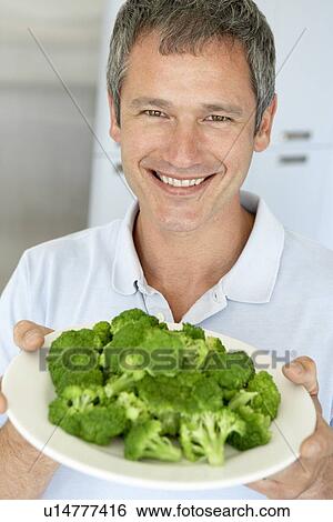 Middle Aged Man Holding A Plate Of Broccoli View Large Photo Image Stock Photograph - Middle Aged Man Holding A Plate Of Broccoli. Fotosearch
