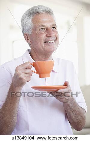 Picture - Middle Aged Man Holding Orange Mug. Fotosearch