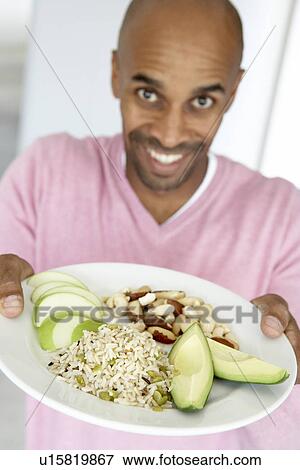 Stock Photo - Middle Aged Man Holding Out A Plate With Healthy Foods. Fotosearch